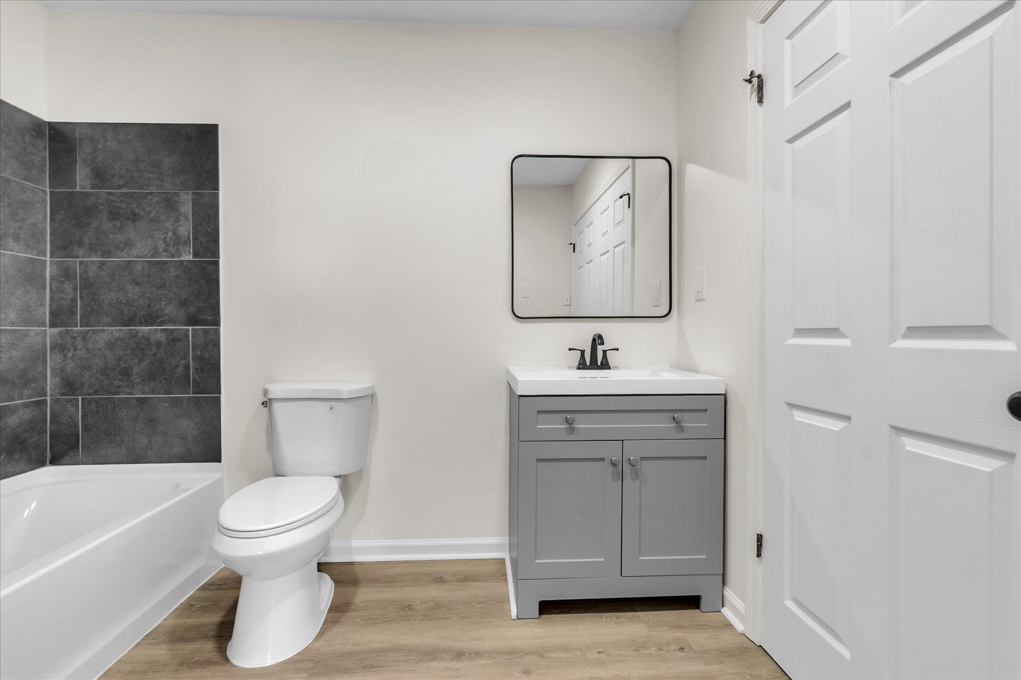 129 Tatlock Circle Covington, TN 38019 - Photo 12 of 16 Bathroom featuring vanity, light wood-type flooring, and a tub to relax in