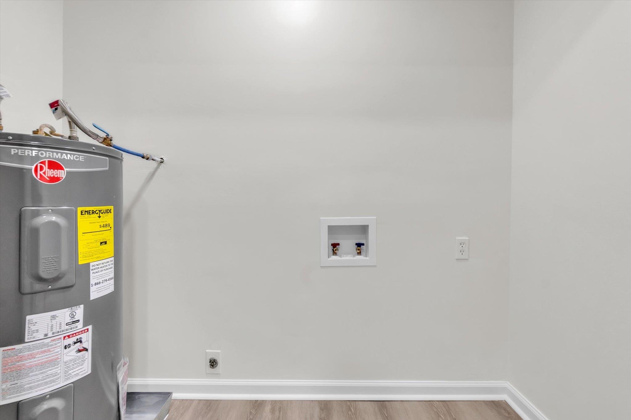 129 Tatlock Circle Covington, TN 38019 - Photo 14 of 16 Laundry area featuring electric water heater, electric dryer hookup, light wood finished floors, and washer hookup