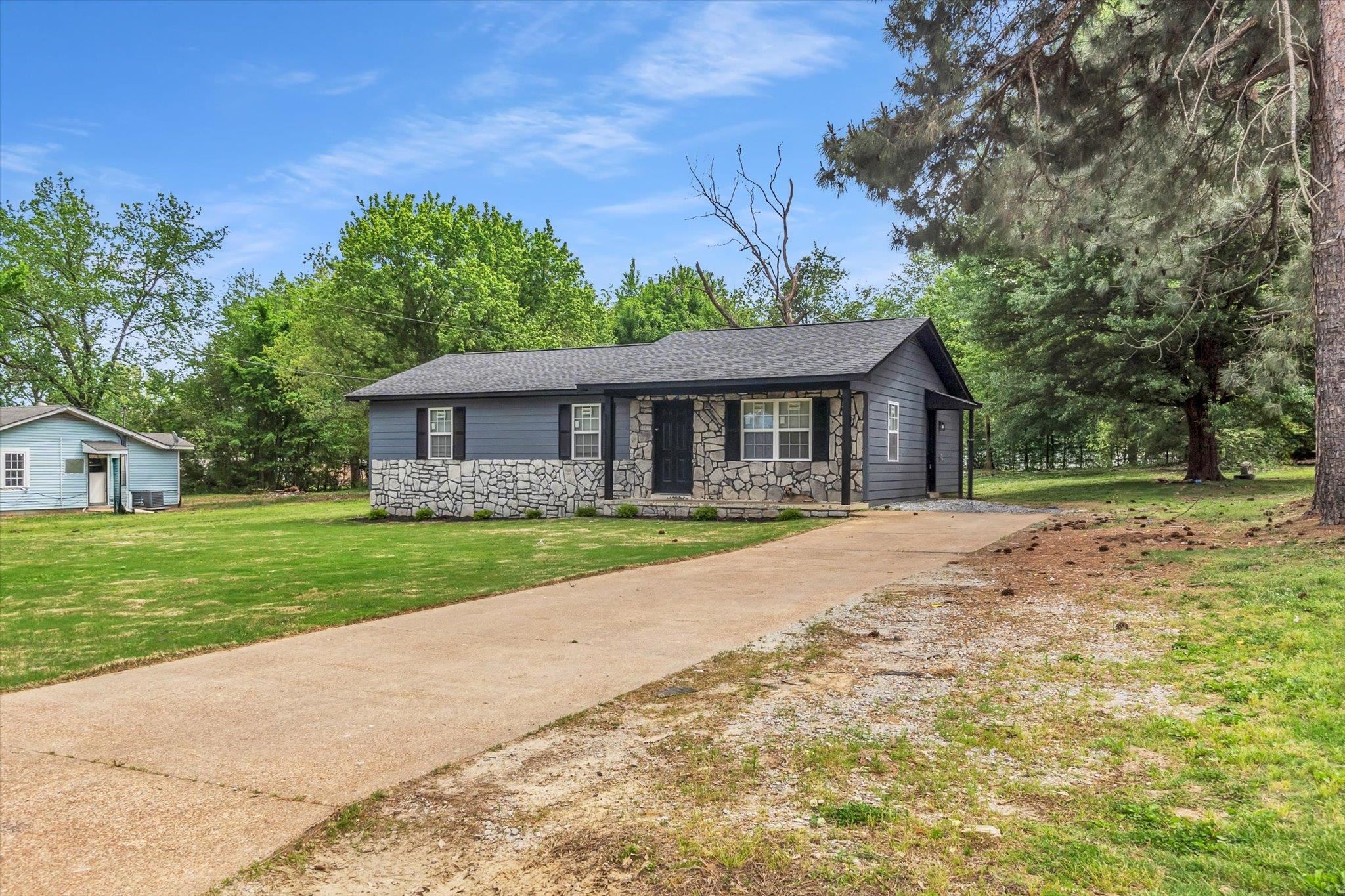 129 Tatlock Circle Covington, TN 38019 - Photo 2 of 16 Single story home with stone siding, a front lawn, roof with shingles, and driveway