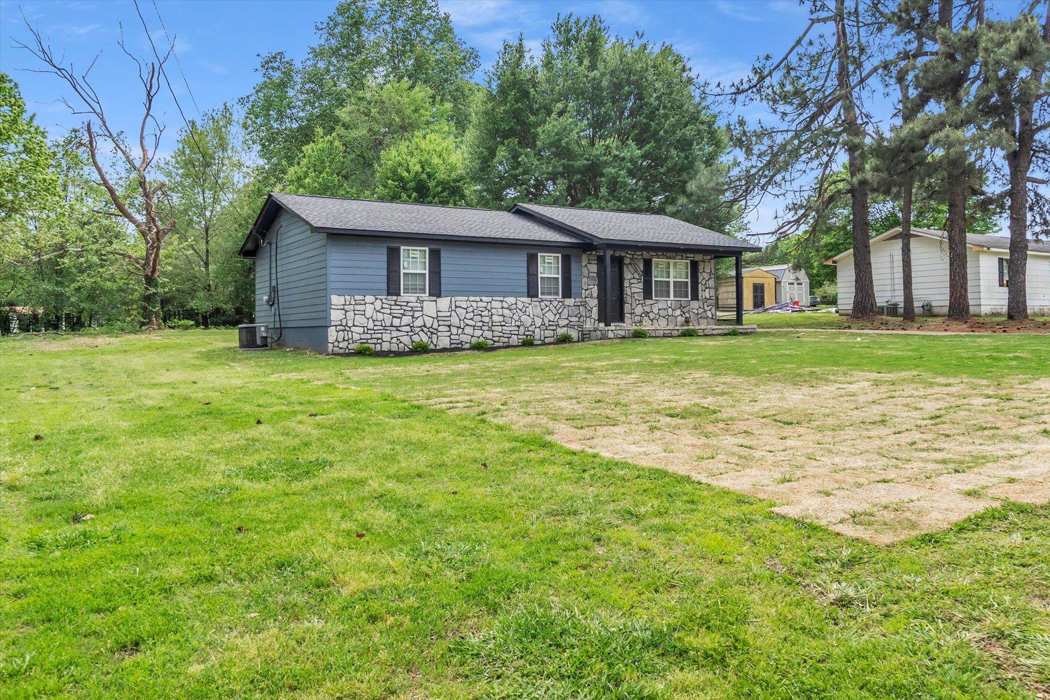 129 Tatlock Circle Covington, TN 38019 - Photo 3 of 16 View of front of house with a front yard, a shingled roof, and stone siding