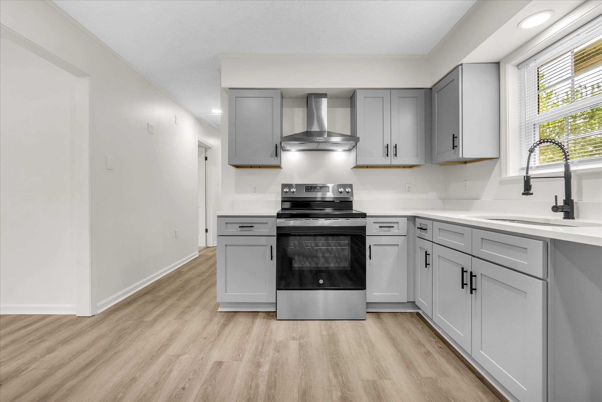 129 Tatlock Circle Covington, TN 38019 - Photo 6 of 16 Kitchen featuring gray cabinets, electric stove, light wood finished floors, recessed lighting, and crown molding