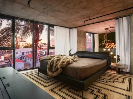 a bedroom with furniture and large windows