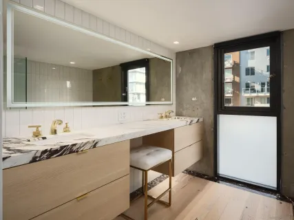 a bathroom with a sink and mirror with bathtub