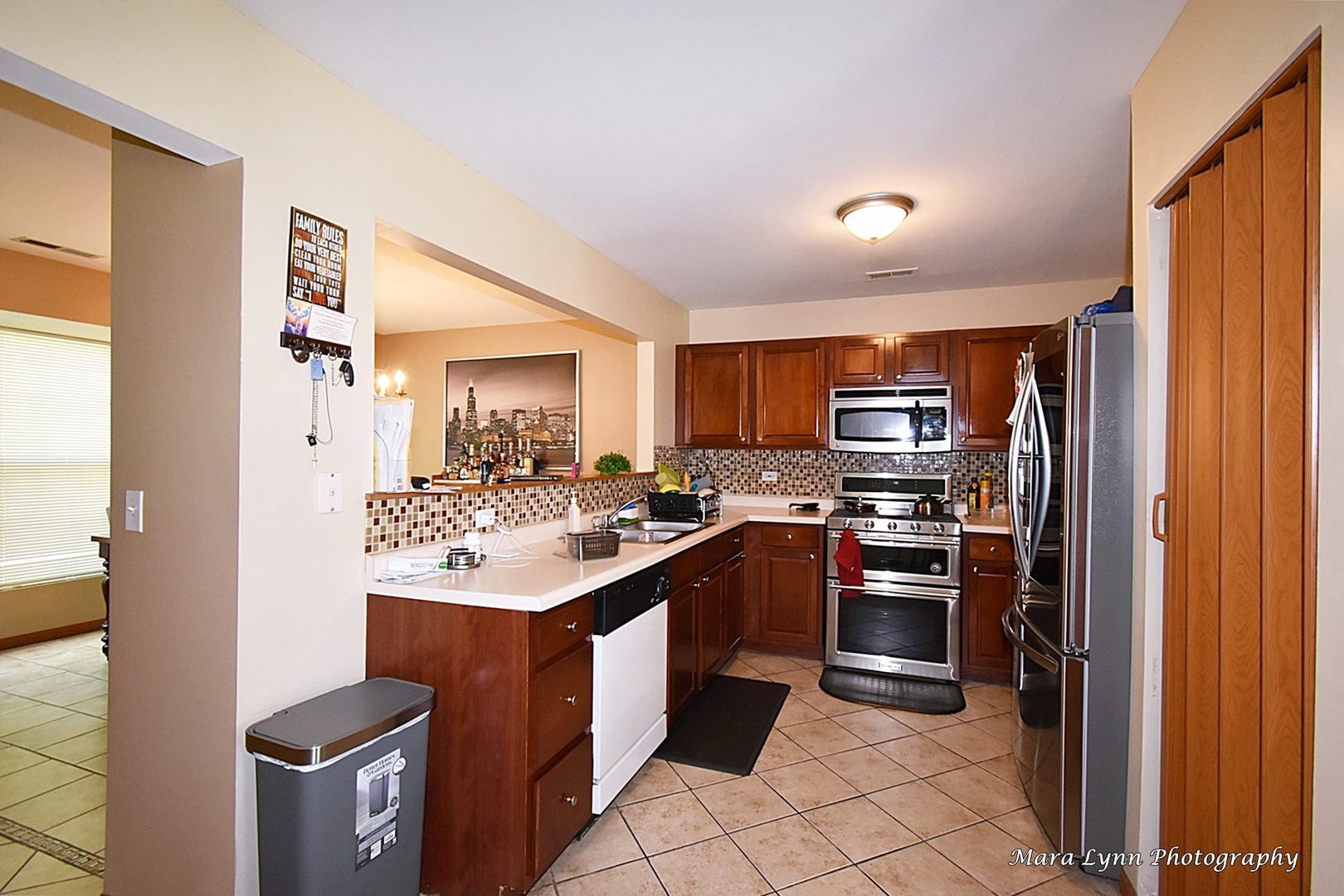 987 Symphony Drive Aurora, IL 60504 - Photo 7 of 27 a kitchen with stainless steel appliances granite countertop a sink stove and refrigerator