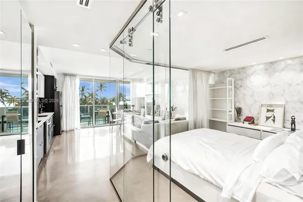 a large bedroom with a large window and bed