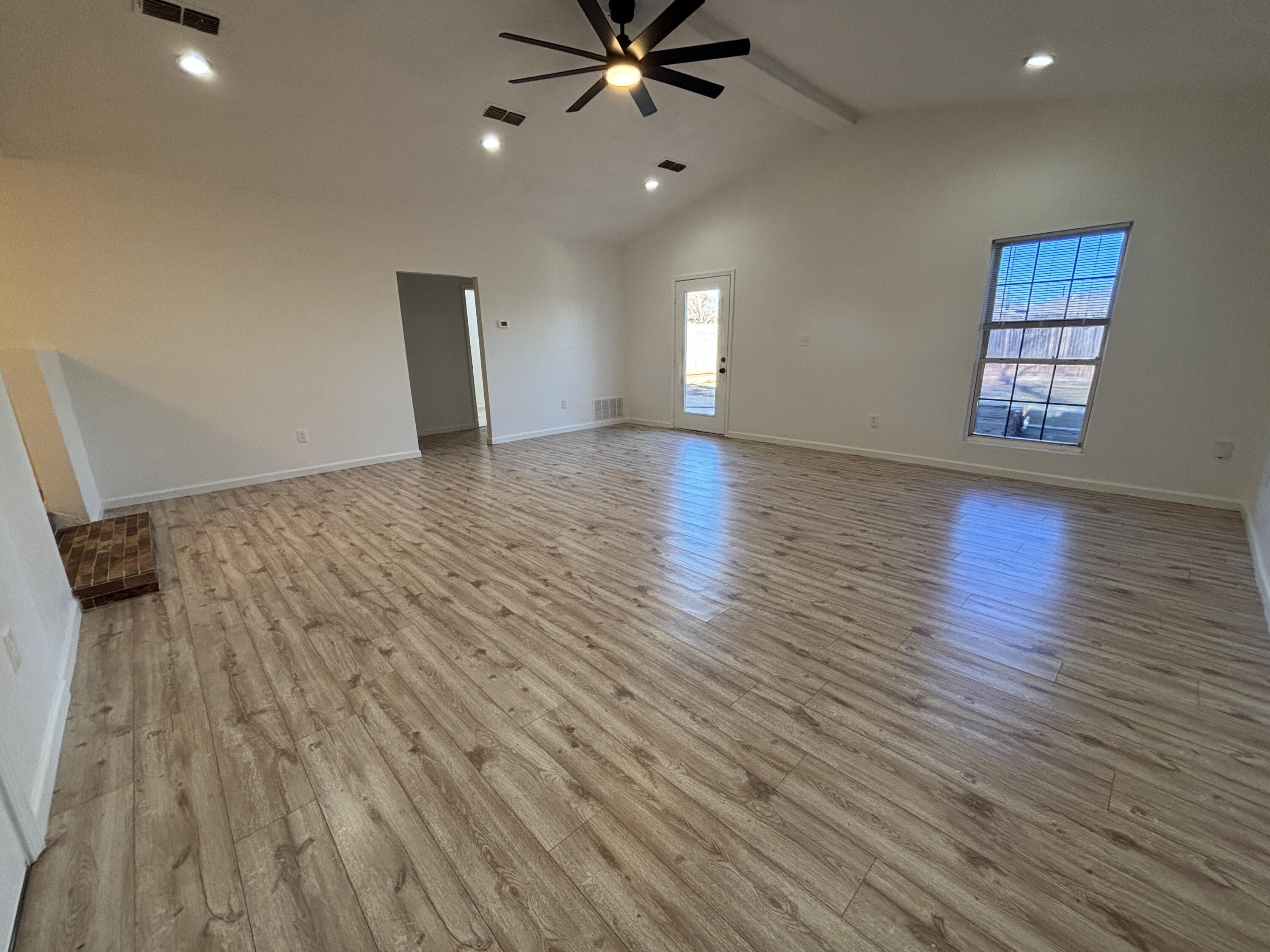 2718 Cornell Street Lubbock, TX 79415 - Photo 3 of 13 wooden floor in an empty room with a window