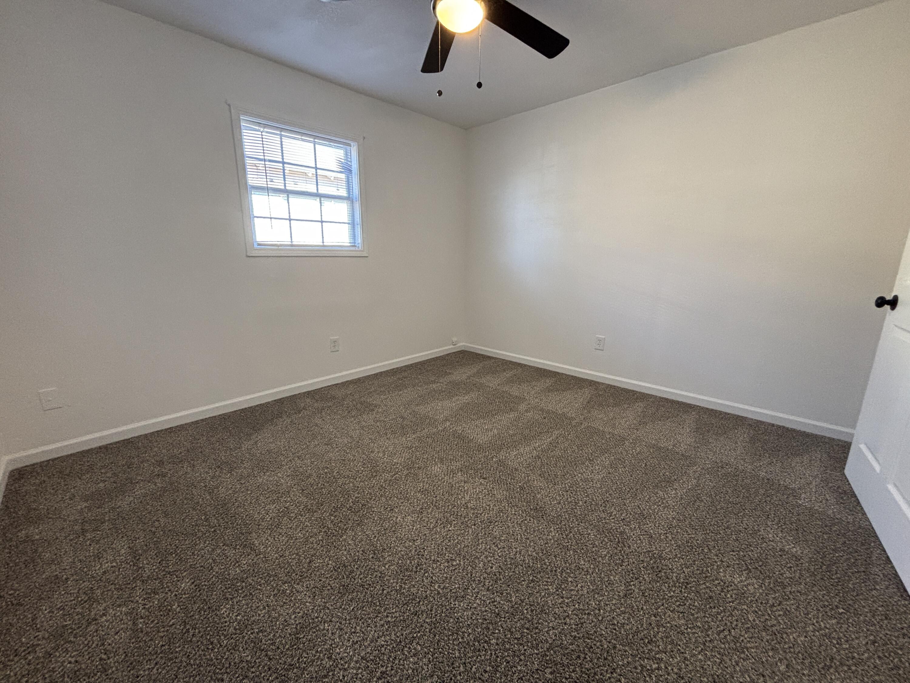 2718 Cornell Street Lubbock, TX 79415 - Photo 7 of 13 an empty room with a window and a fireplace