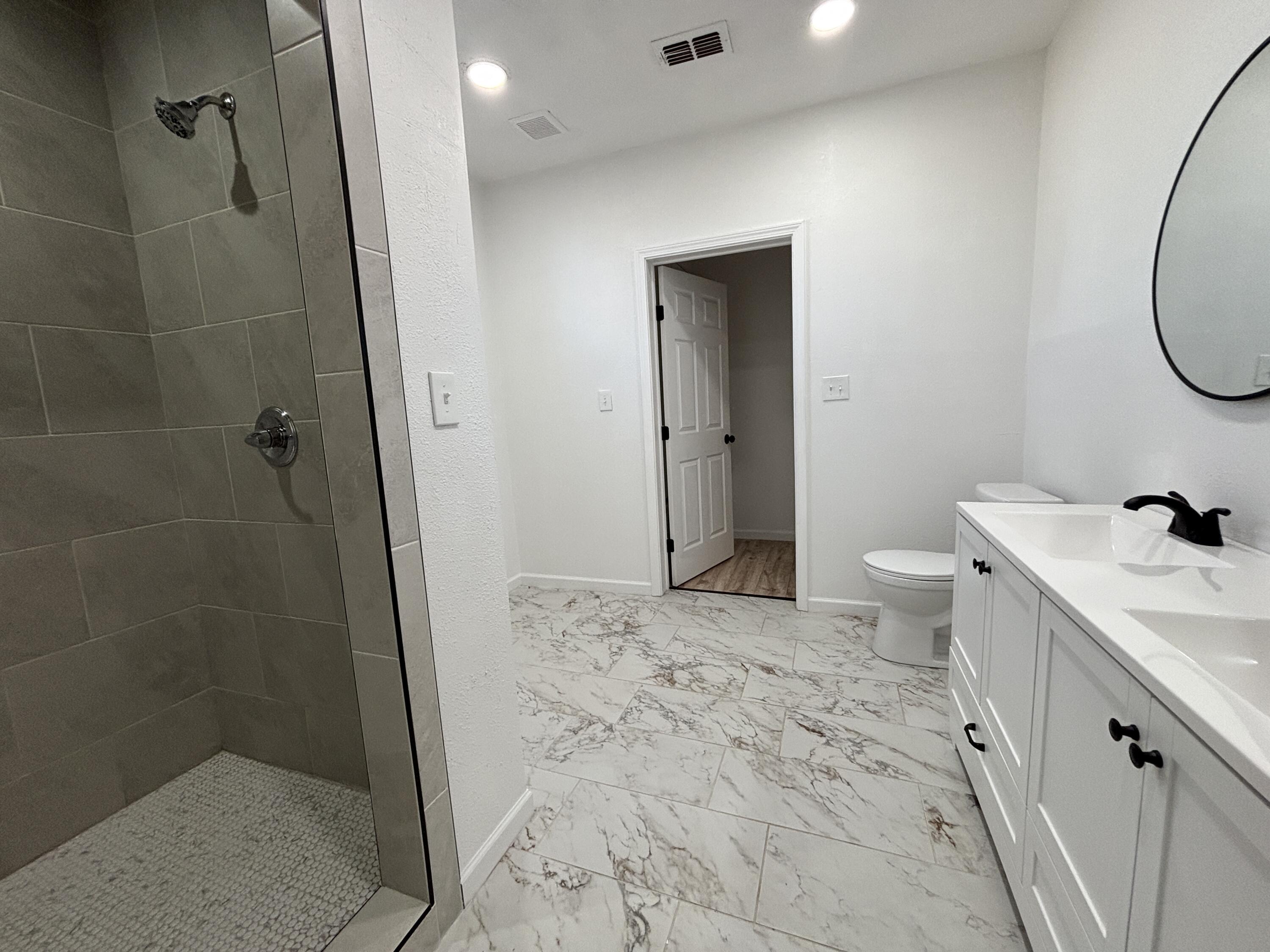 2718 Cornell Street Lubbock, TX 79415 - Photo 9 of 13 a bathroom with a sink a toilet and shower