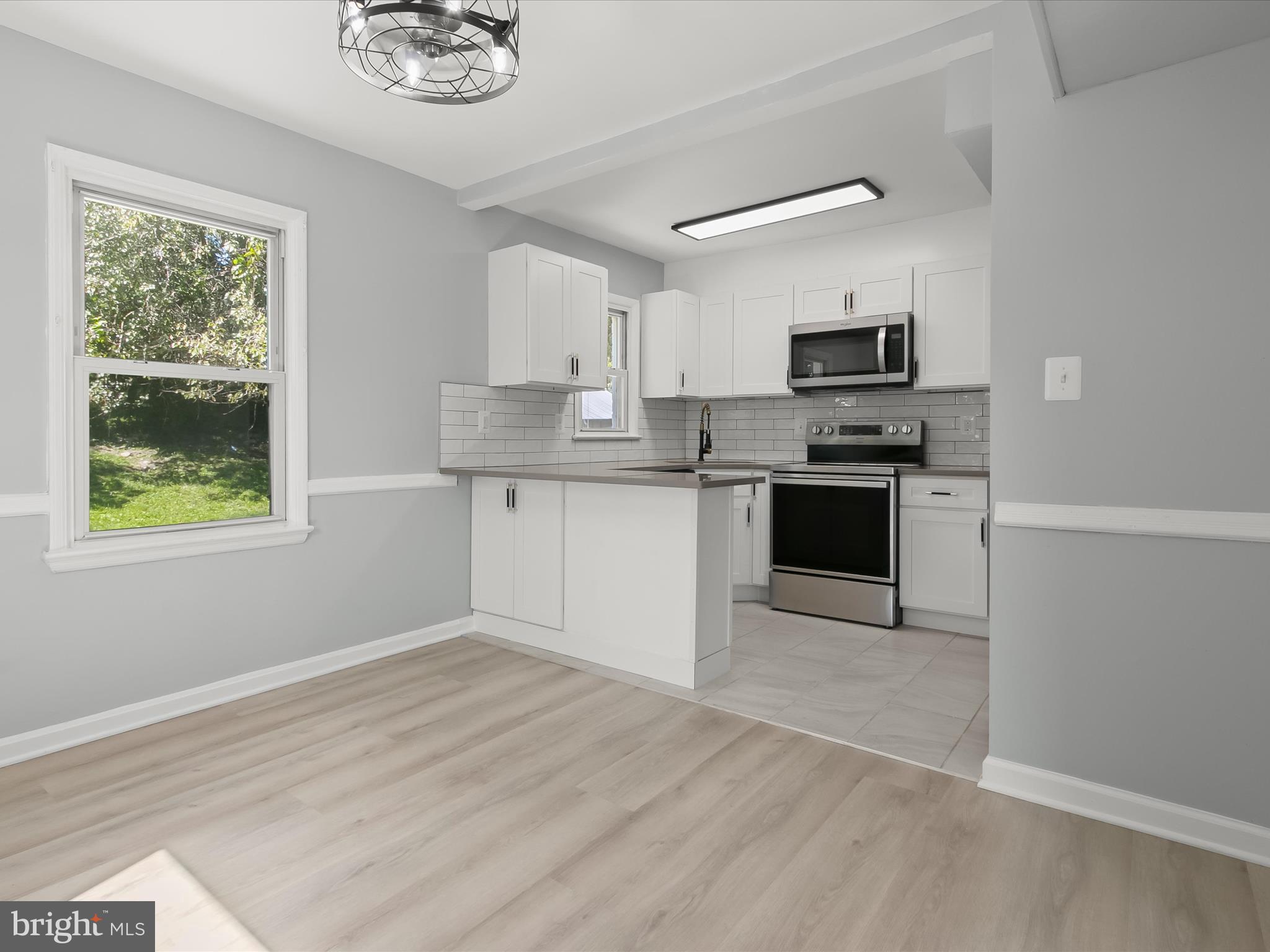 6806 10th Avenue Takoma Park, MD 20912 - Photo 12 of 39 a kitchen with stainless steel appliances granite countertop a stove top oven a sink dishwasher and a refrigerator with wooden floor
