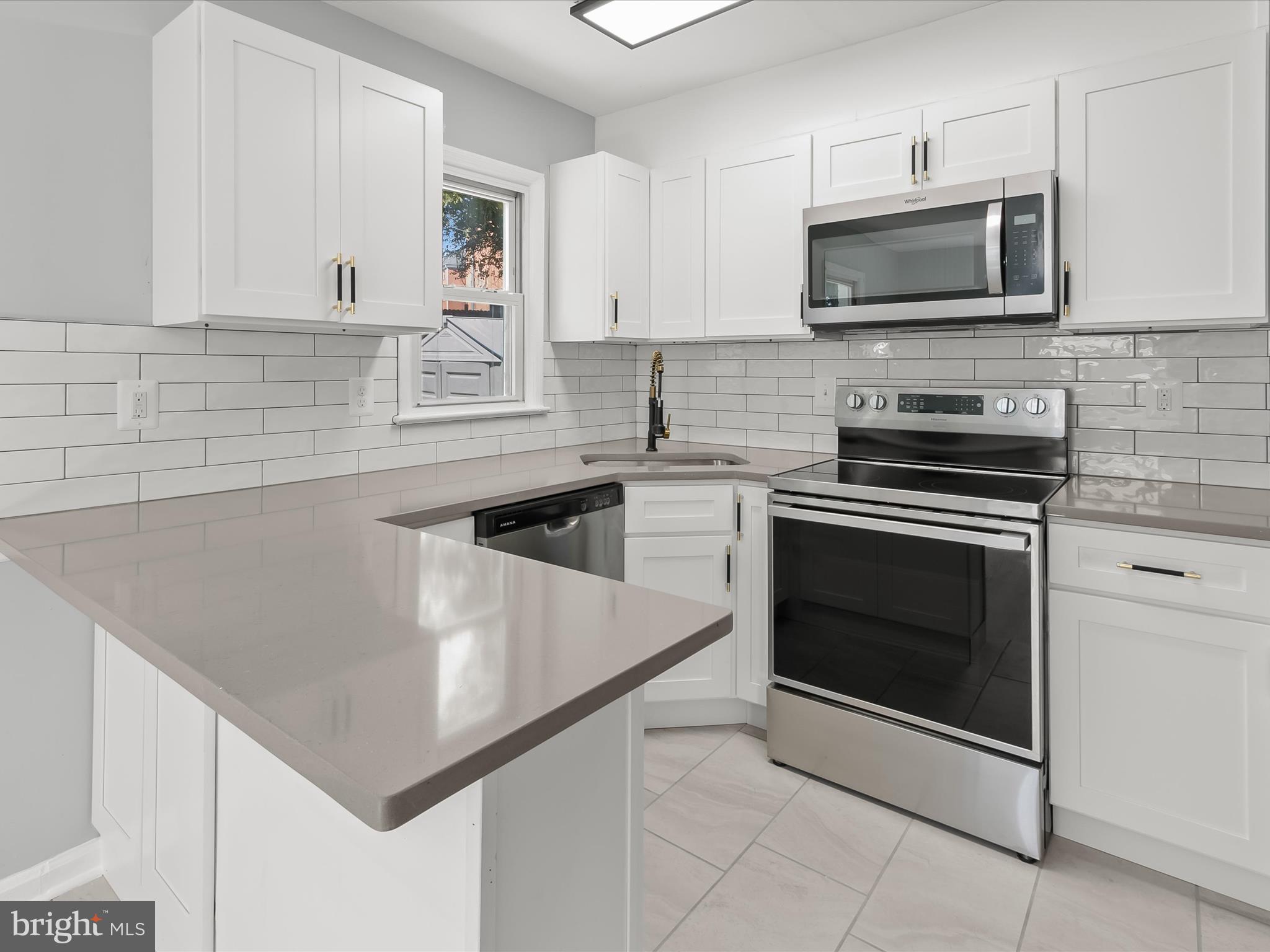 6806 10th Avenue Takoma Park, MD 20912 - Photo 16 of 39 a kitchen with sink a microwave and cabinets