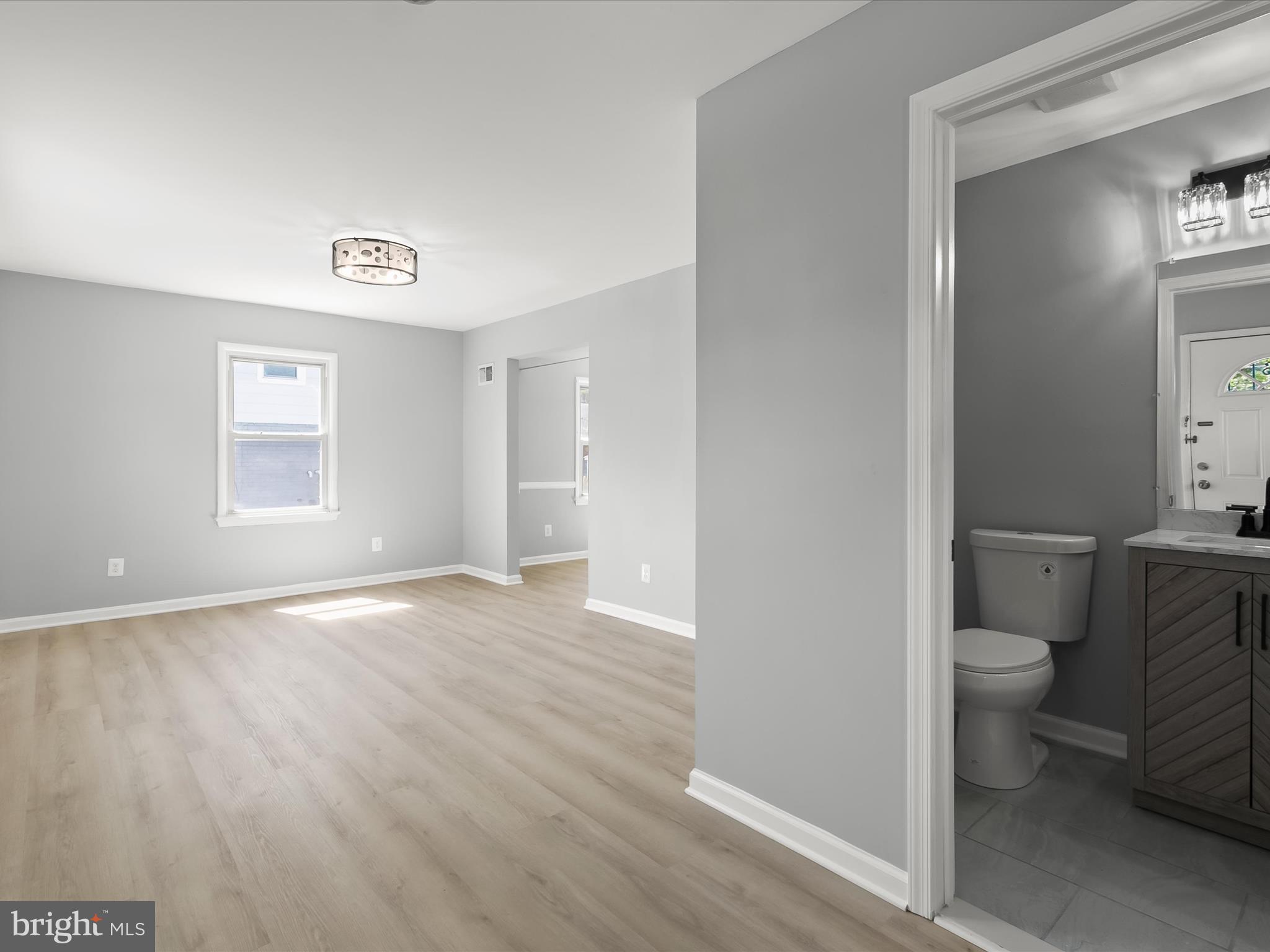 6806 10th Avenue Takoma Park, MD 20912 - Photo 5 of 39 a big room with wooden floor and a toilet