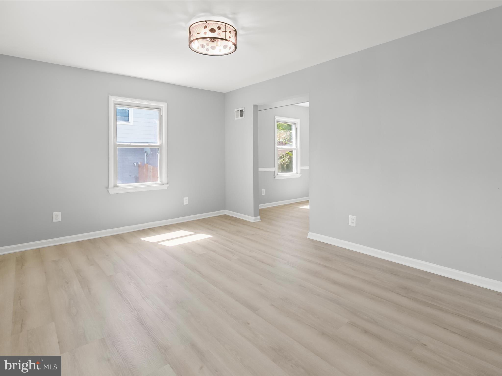 6806 10th Avenue Takoma Park, MD 20912 - Photo 7 of 39 an empty room with wooden floor and windows