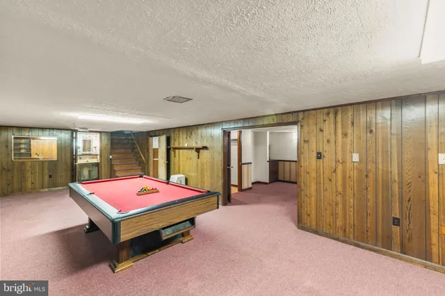 an outdoor space with pool table and couches