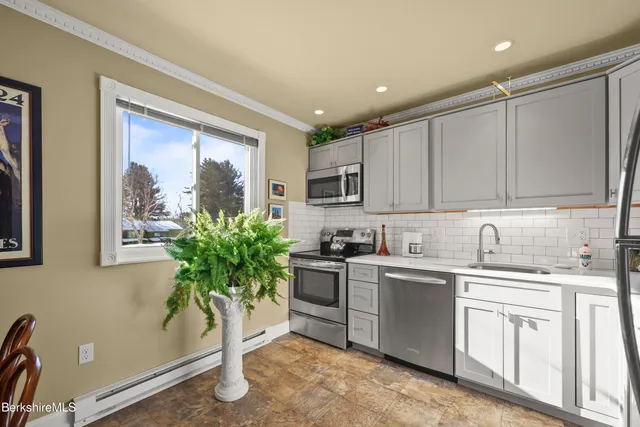a kitchen with stainless steel appliances granite countertop a sink a stove and cabinets