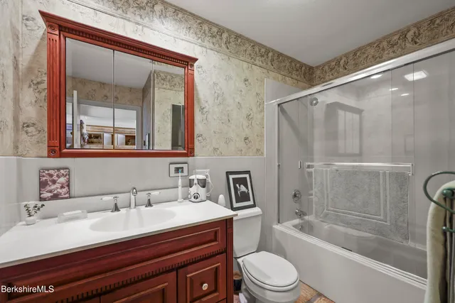 a bathroom with a sink mirror and toilet