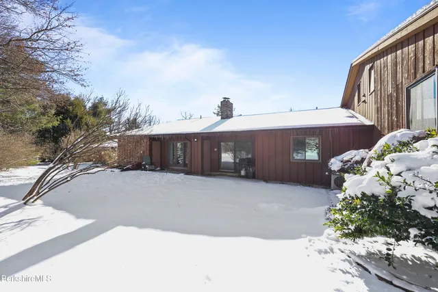 a view of a roof deck with wooden fence and a couple of chairs