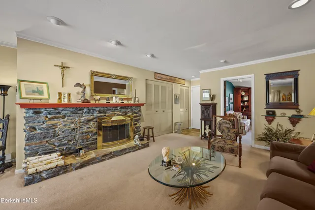 a living room with fireplace furniture and a potted plant