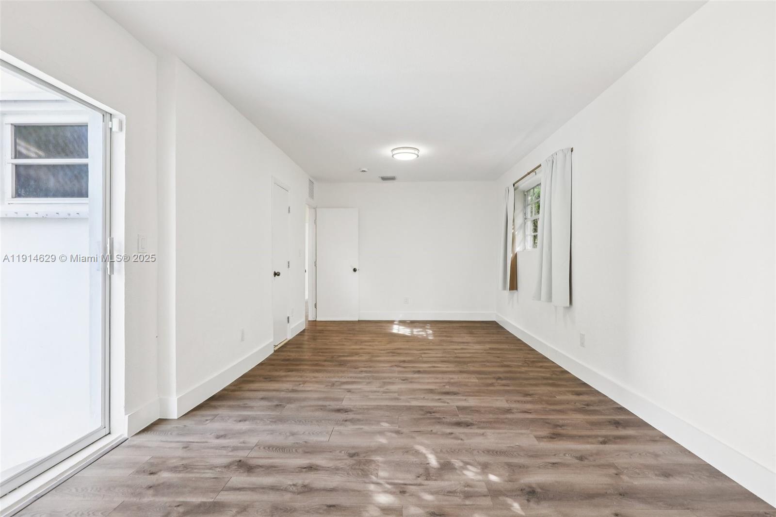 12630 Northeast Miami Place North Miami, FL 33161 - Photo 30 of 66 an empty room with wooden floor and windows
