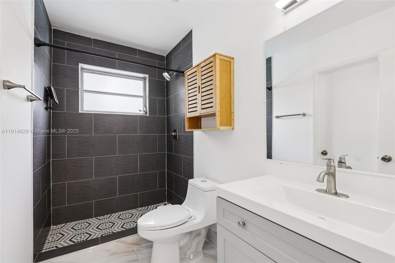 12630 Northeast Miami Place North Miami, FL 33161 - Photo 35 of 66 a bathroom with a sink a toilet a mirror and shower