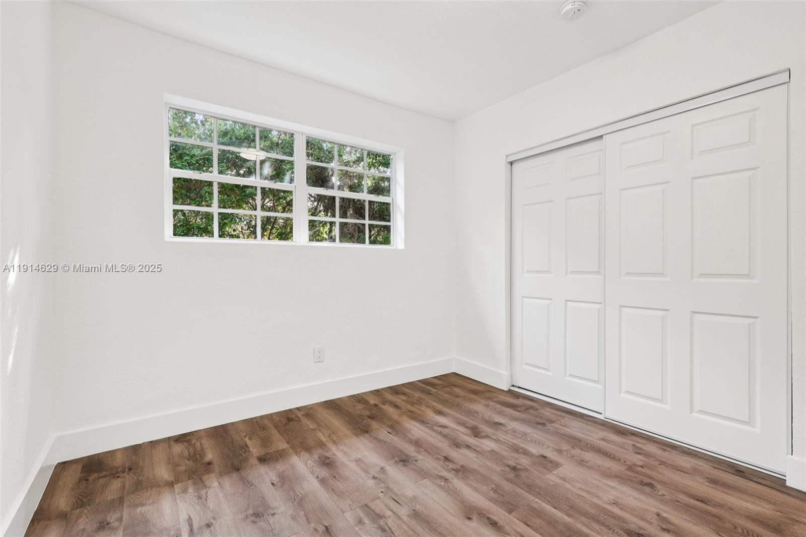 12630 Northeast Miami Place North Miami, FL 33161 - Photo 39 of 66 an empty room with wooden floor and windows
