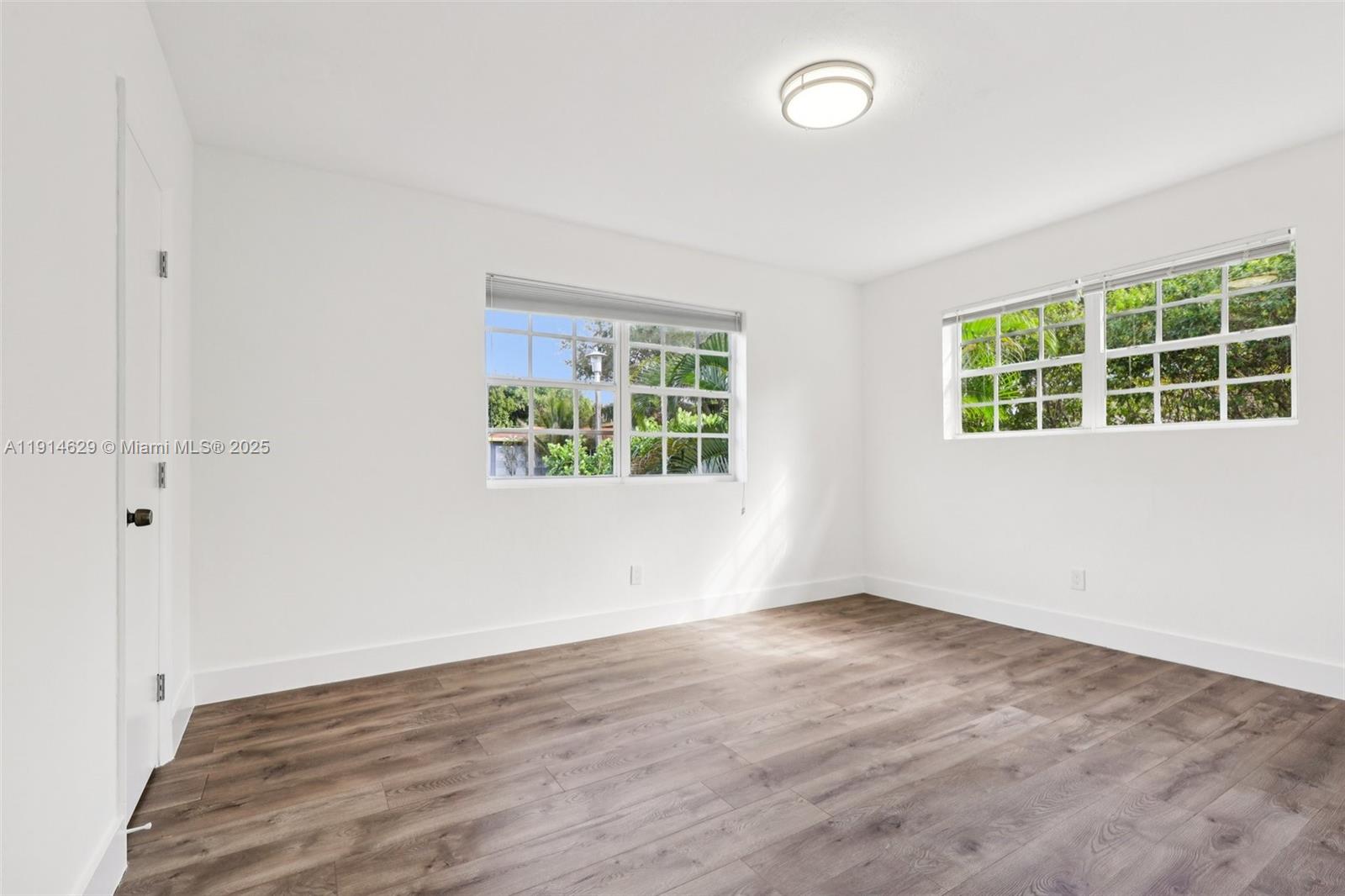 12630 Northeast Miami Place North Miami, FL 33161 - Photo 40 of 66 an empty room with wooden floor and windows