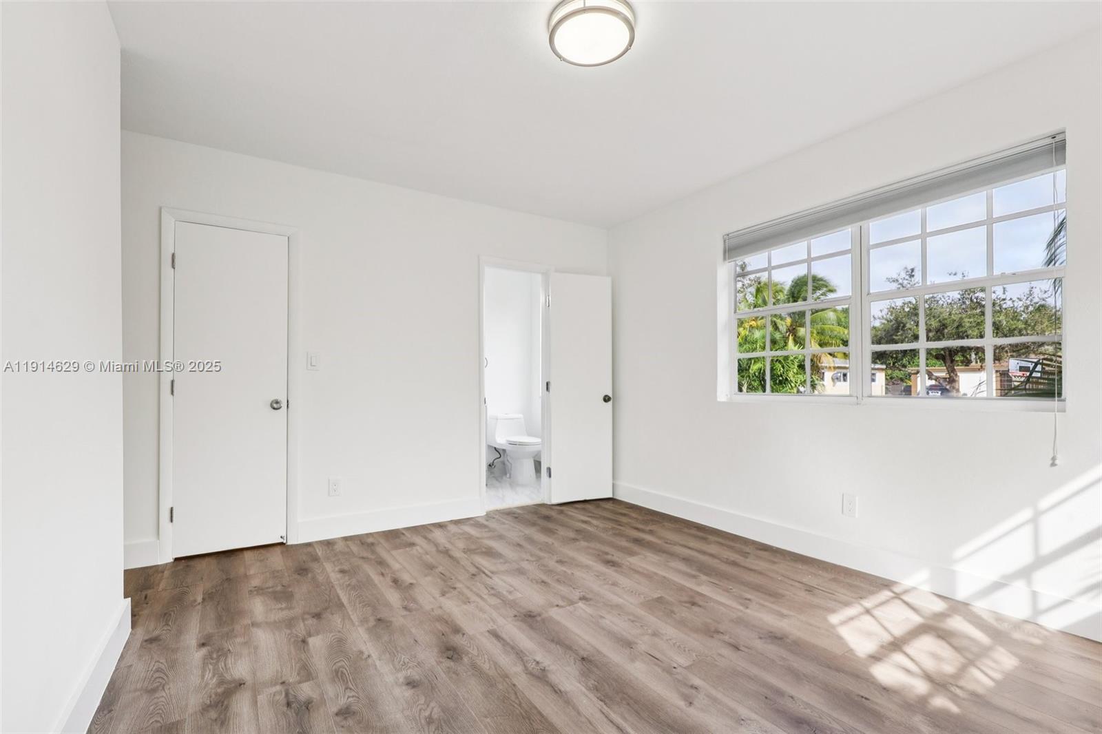 12630 Northeast Miami Place North Miami, FL 33161 - Photo 41 of 66 wooden floor in an empty room with a window