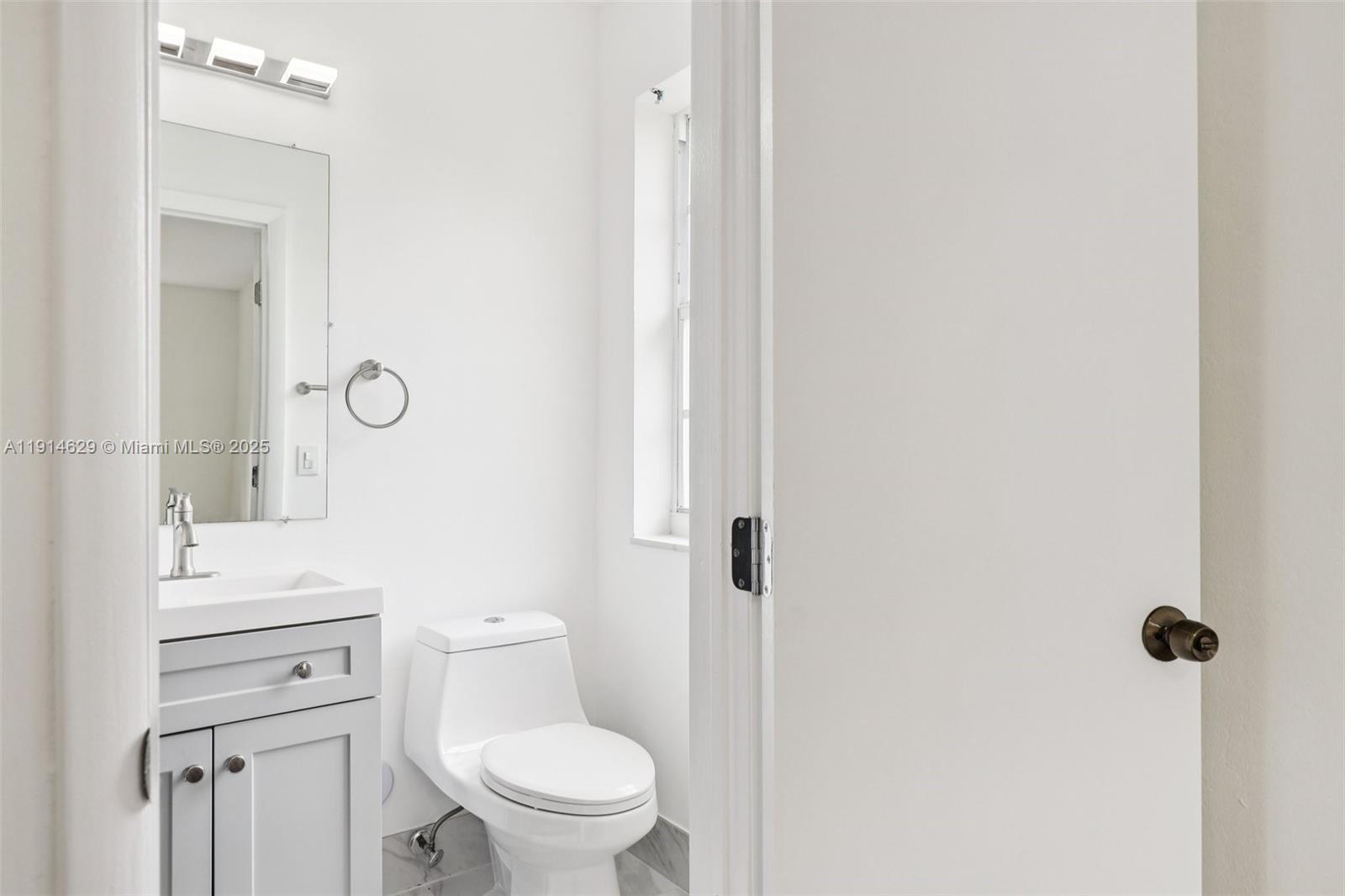 12630 Northeast Miami Place North Miami, FL 33161 - Photo 44 of 66 a bathroom with a toilet a sink and a mirror