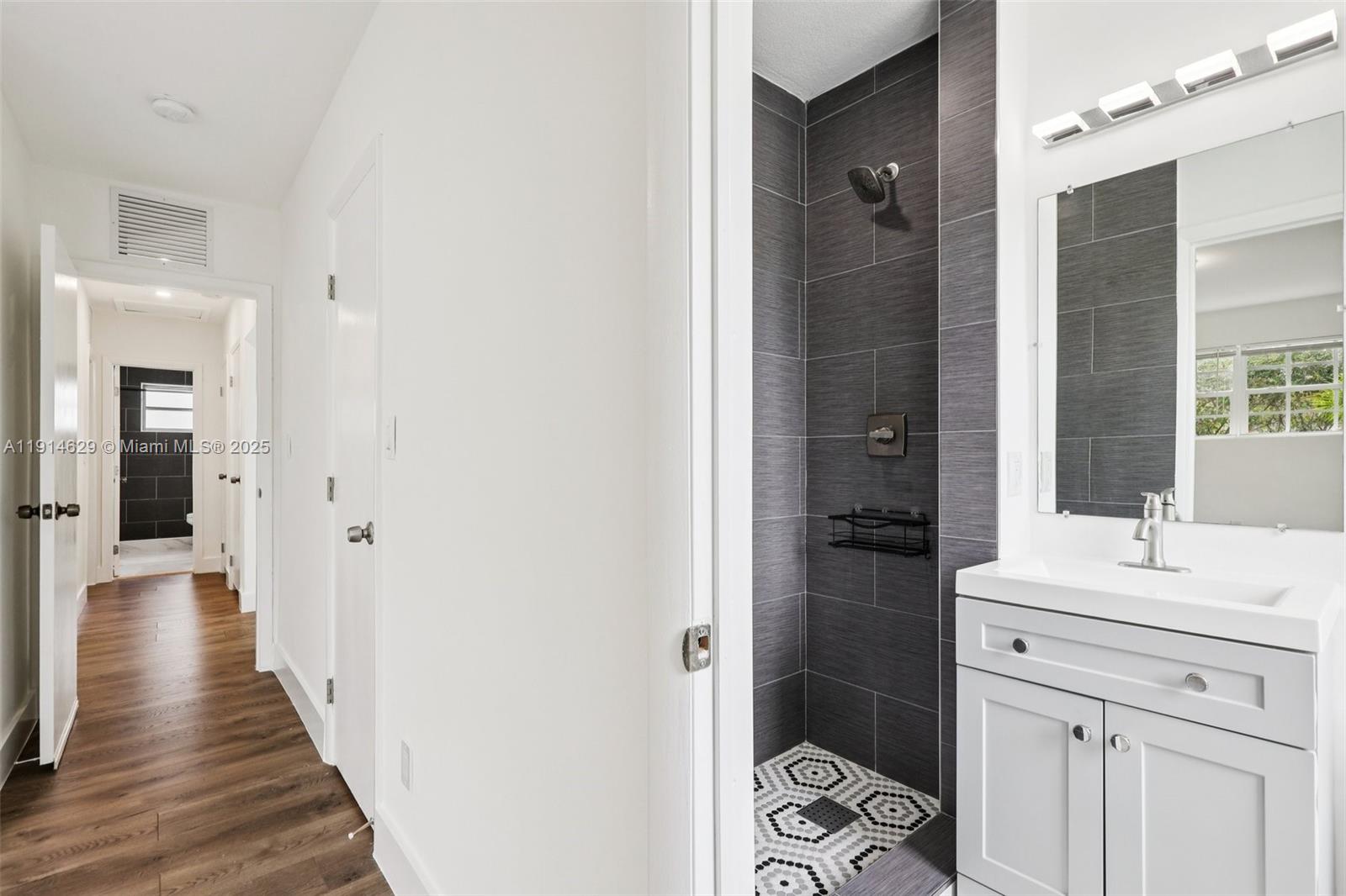 12630 Northeast Miami Place North Miami, FL 33161 - Photo 45 of 66 a bathroom with a sink a mirror and a shower