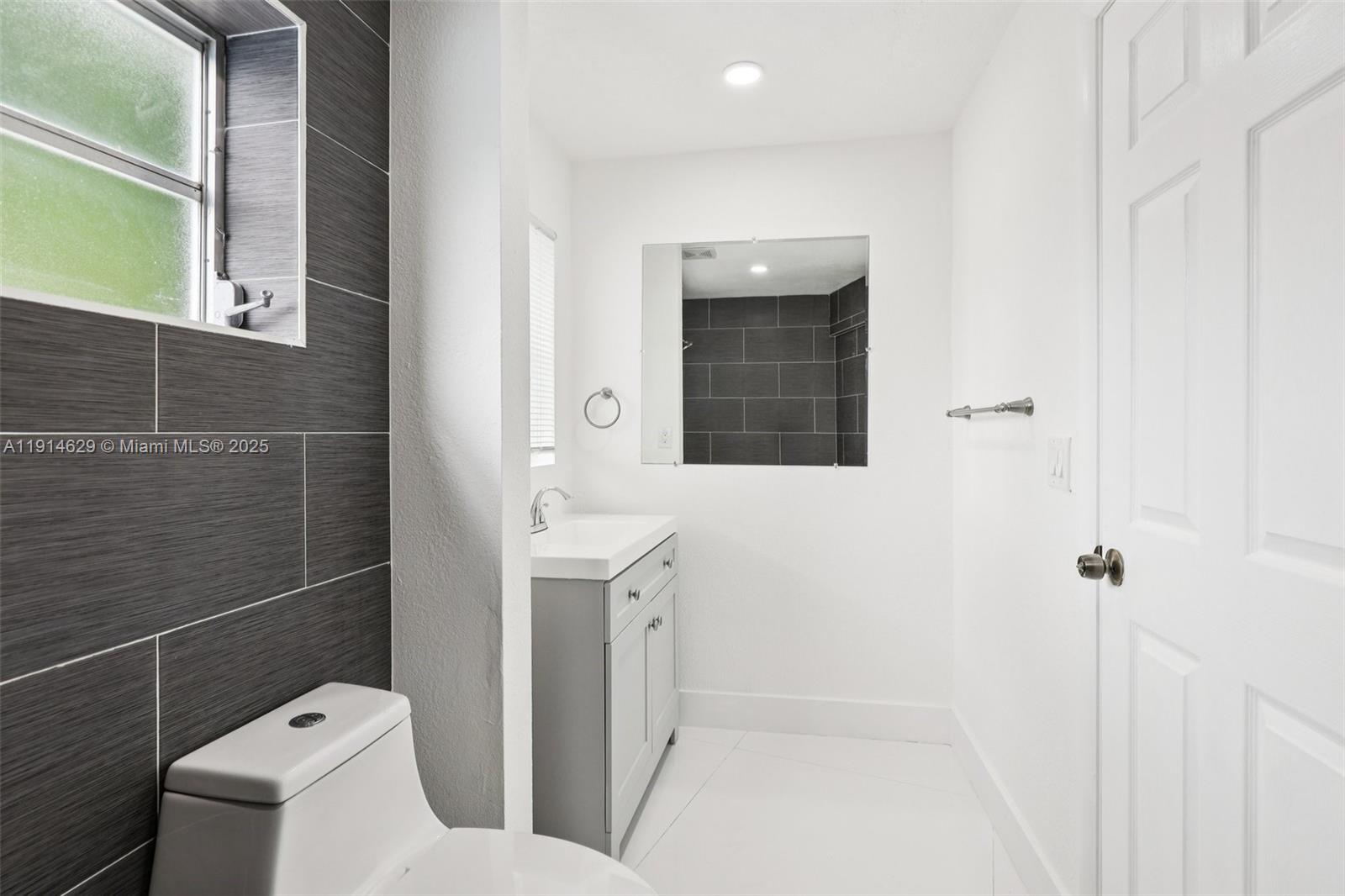 12630 Northeast Miami Place North Miami, FL 33161 - Photo 57 of 66 a bathroom with a toilet sink and mirror