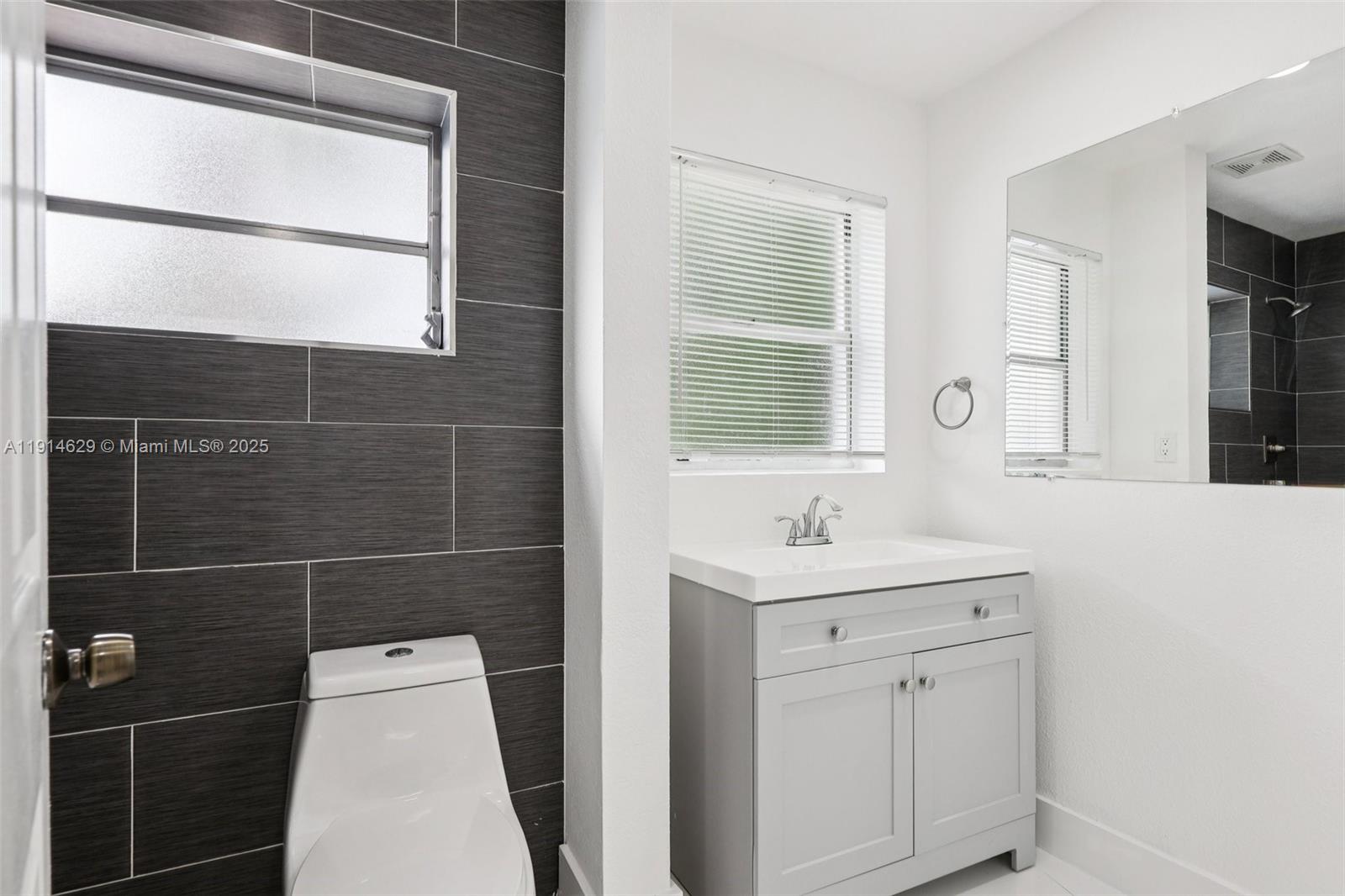 12630 Northeast Miami Place North Miami, FL 33161 - Photo 58 of 66 a bathroom with a sink a toilet and a mirror