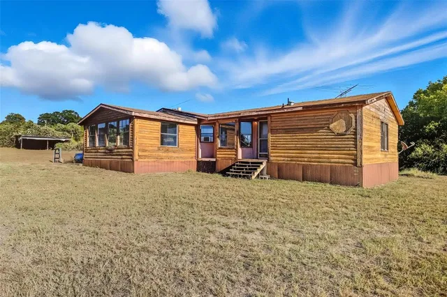 a view of a house with a backyard
