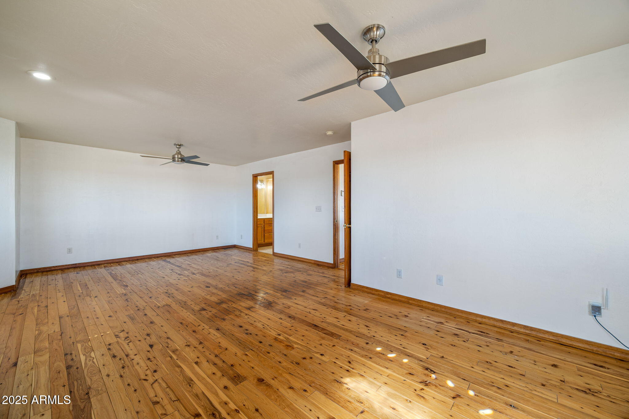 800 Arena Estates Taylor, AZ 85939 - Photo 23 of 50 a view of a big room with wooden floor and a ceiling fan