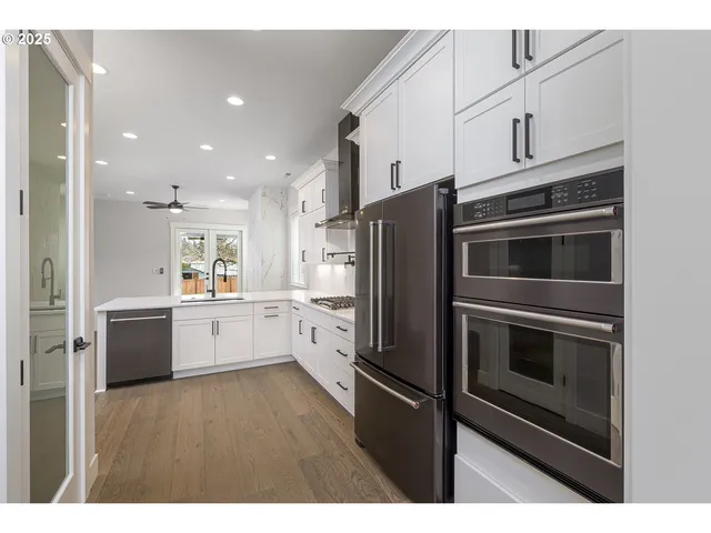 a kitchen with stainless steel appliances kitchen island granite countertop a stove a refrigerator and a sink