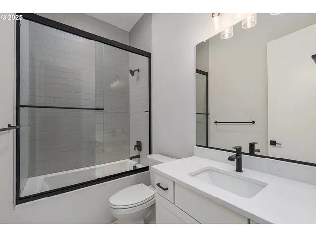 a bathroom with a sink toilet a mirror and shower