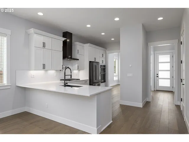 a kitchen with kitchen island white cabinets and stainless steel appliances
