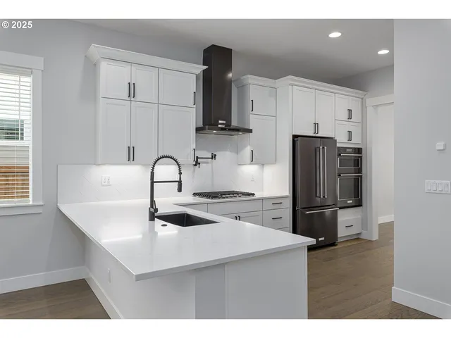 a kitchen with stainless steel appliances a sink refrigerator and cabinets