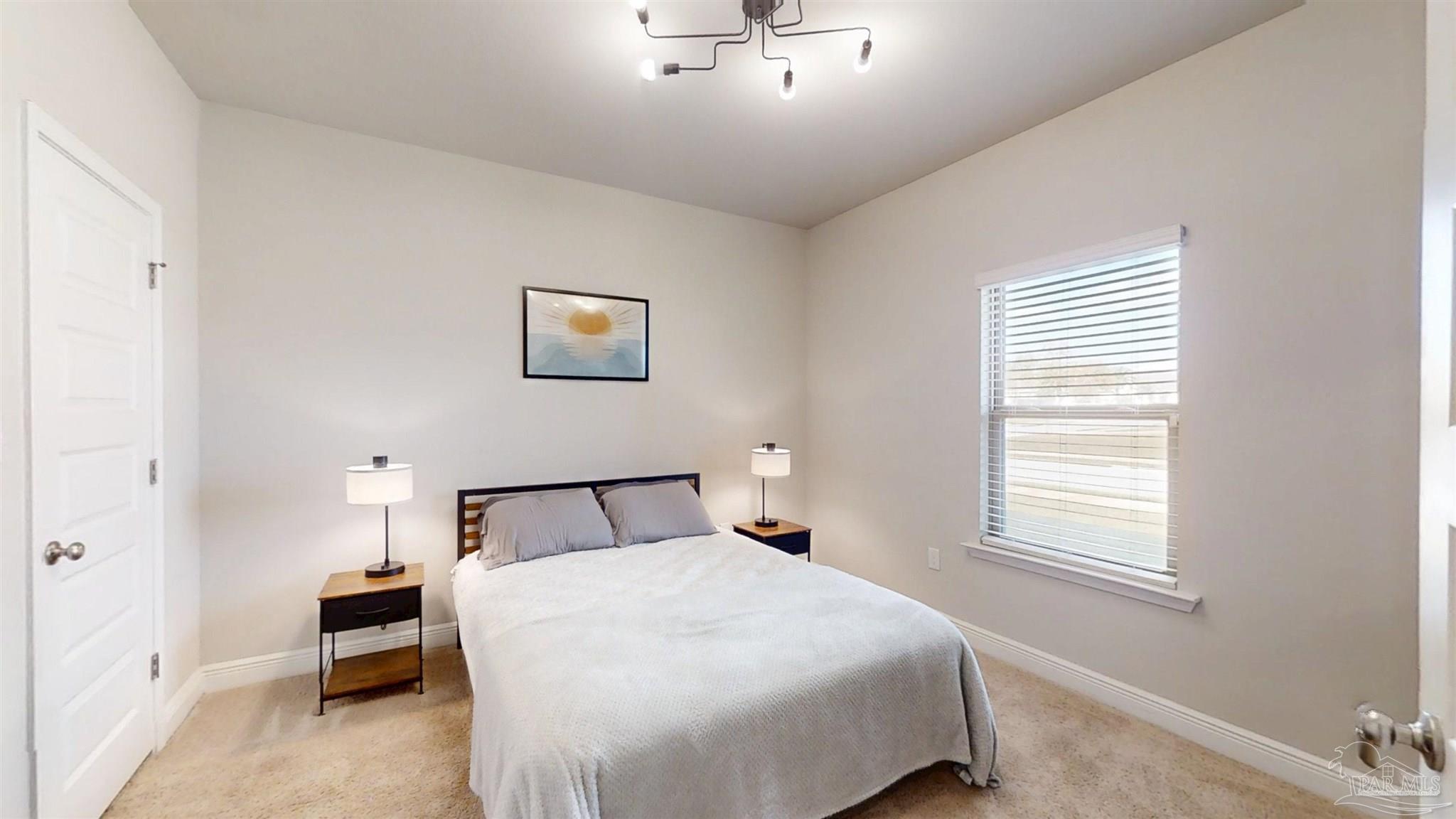 421 Apollo Avenue Gulf Shores, AL 36542 - Photo 12 of 72 a bedroom with a bed and a chandelier