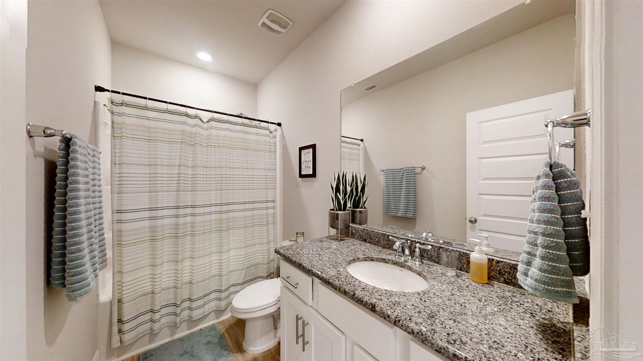 421 Apollo Avenue Gulf Shores, AL 36542 - Photo 17 of 72 a bathroom with a granite countertop sink toilet and shower