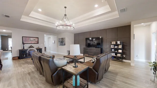 a view of a dining room with furniture a chandelier and wooden floor