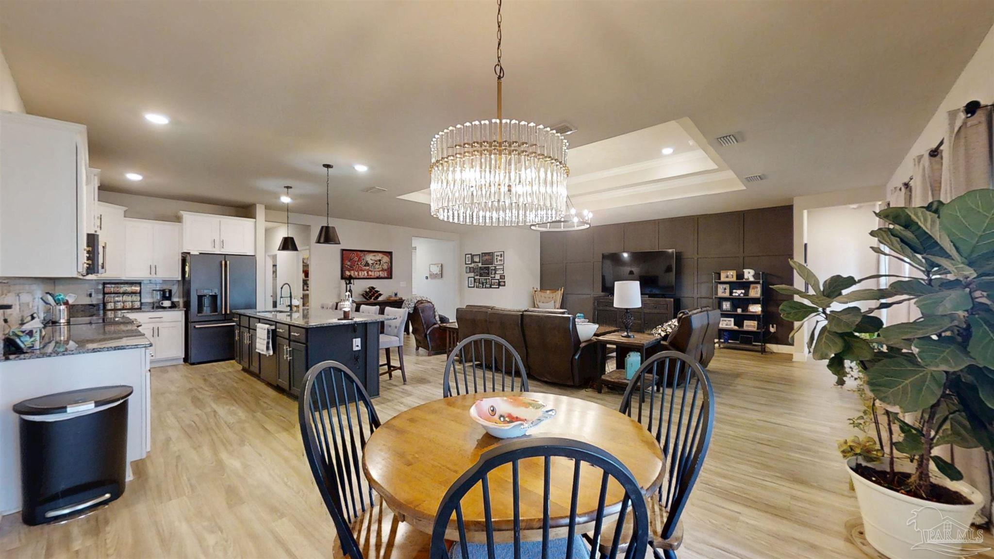 421 Apollo Avenue Gulf Shores, AL 36542 - Photo 29 of 72 a view of a dining room with furniture a chandelier and wooden floor