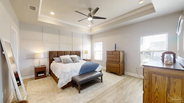 a bedroom with a bed a dresser and a flat screen tv