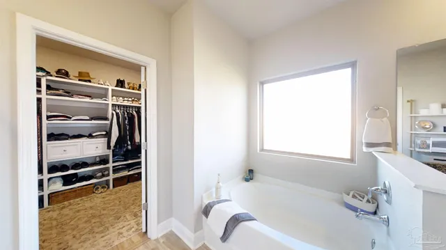 a living room with couches a flat screen tv and a floor to ceiling window