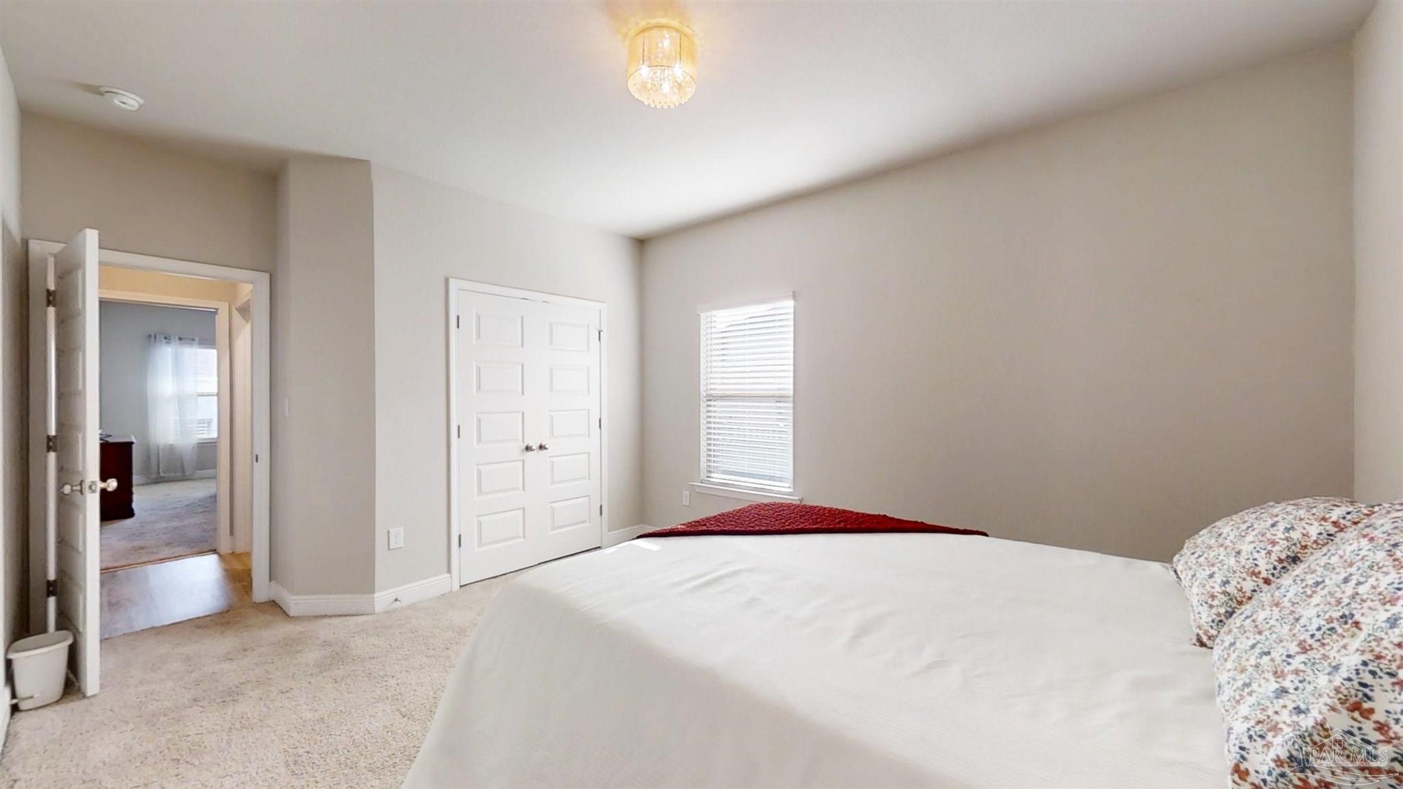 421 Apollo Avenue Gulf Shores, AL 36542 - Photo 39 of 72 a bedroom with a bed and a chandelier