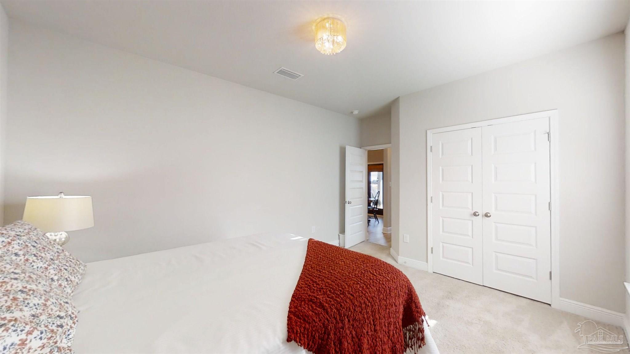 421 Apollo Avenue Gulf Shores, AL 36542 - Photo 40 of 72 a bedroom with a bed and a lamp