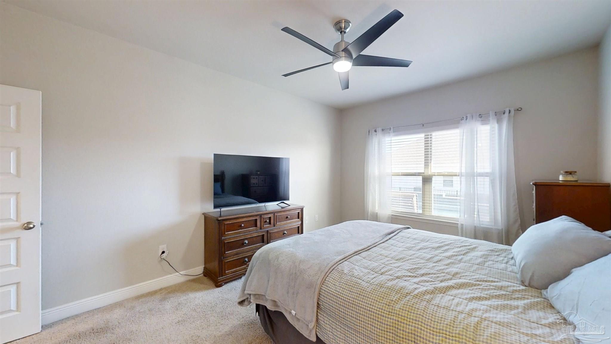 421 Apollo Avenue Gulf Shores, AL 36542 - Photo 45 of 72 a bedroom with a large bed and a flat tv screen on a dresser