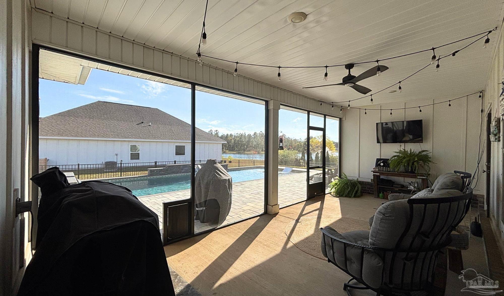 421 Apollo Avenue Gulf Shores, AL 36542 - Photo 48 of 72 a living room with couches a flat screen tv and a floor to ceiling window