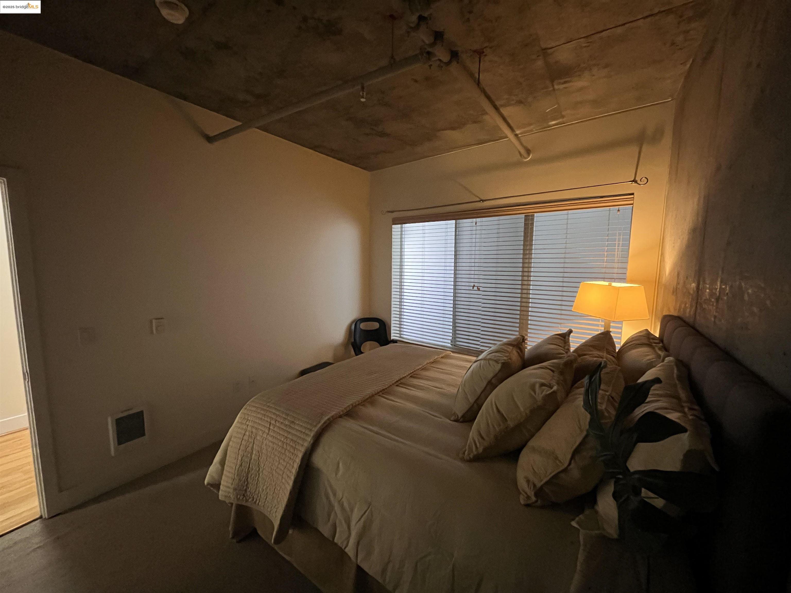 311 Oak Street, Unit 724 Oakland, CA 94607 - Photo 12 of 16 a bed sitting in a bedroom next to a window