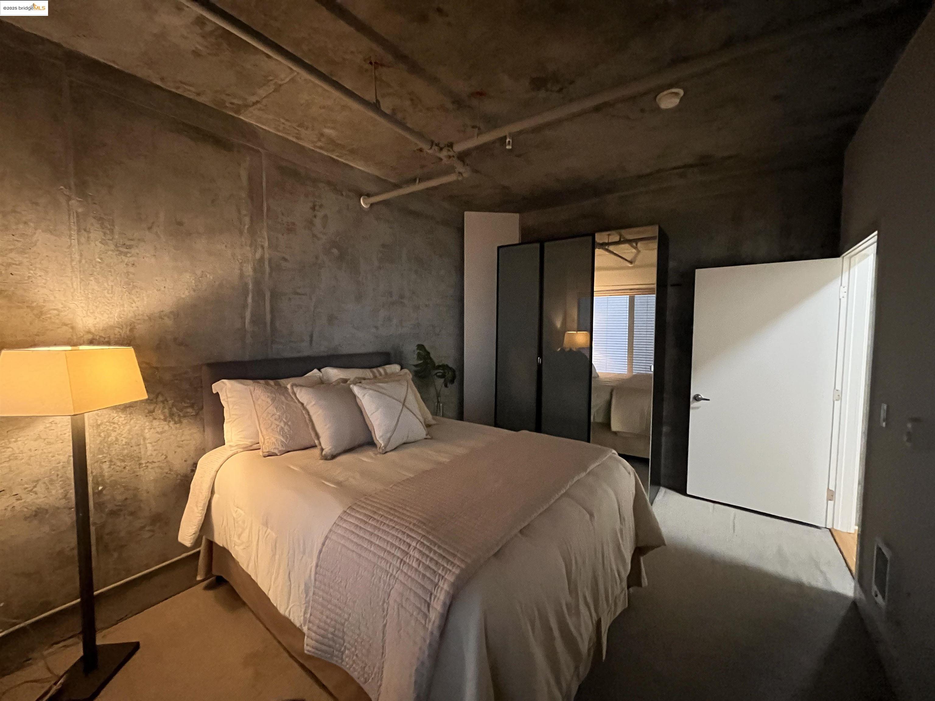 311 Oak Street, Unit 724 Oakland, CA 94607 - Photo 13 of 16 a bed room with a bed and a mirror