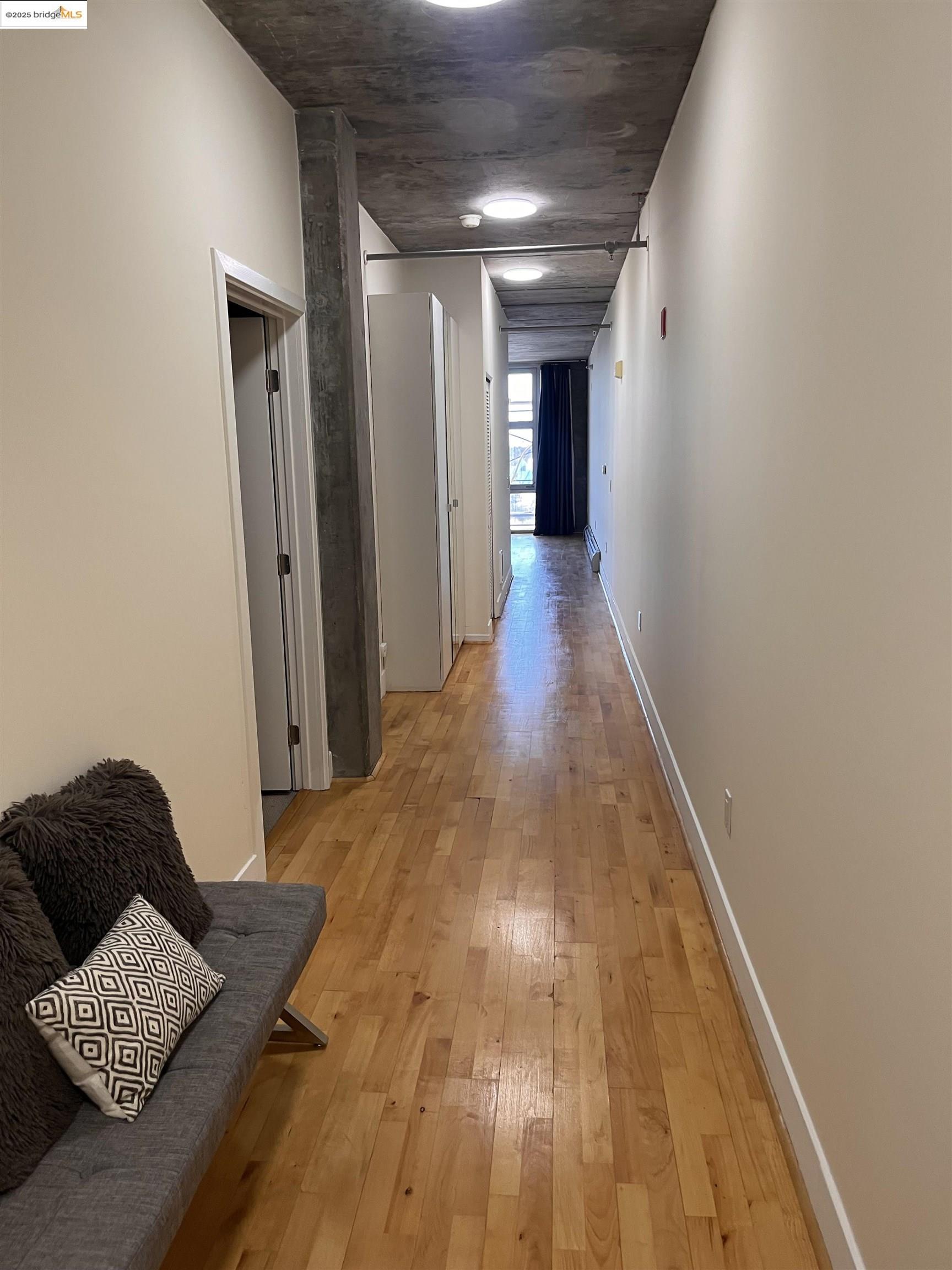 311 Oak Street, Unit 724 Oakland, CA 94607 - Photo 15 of 16 a view of hallway with wooden floor and a rug