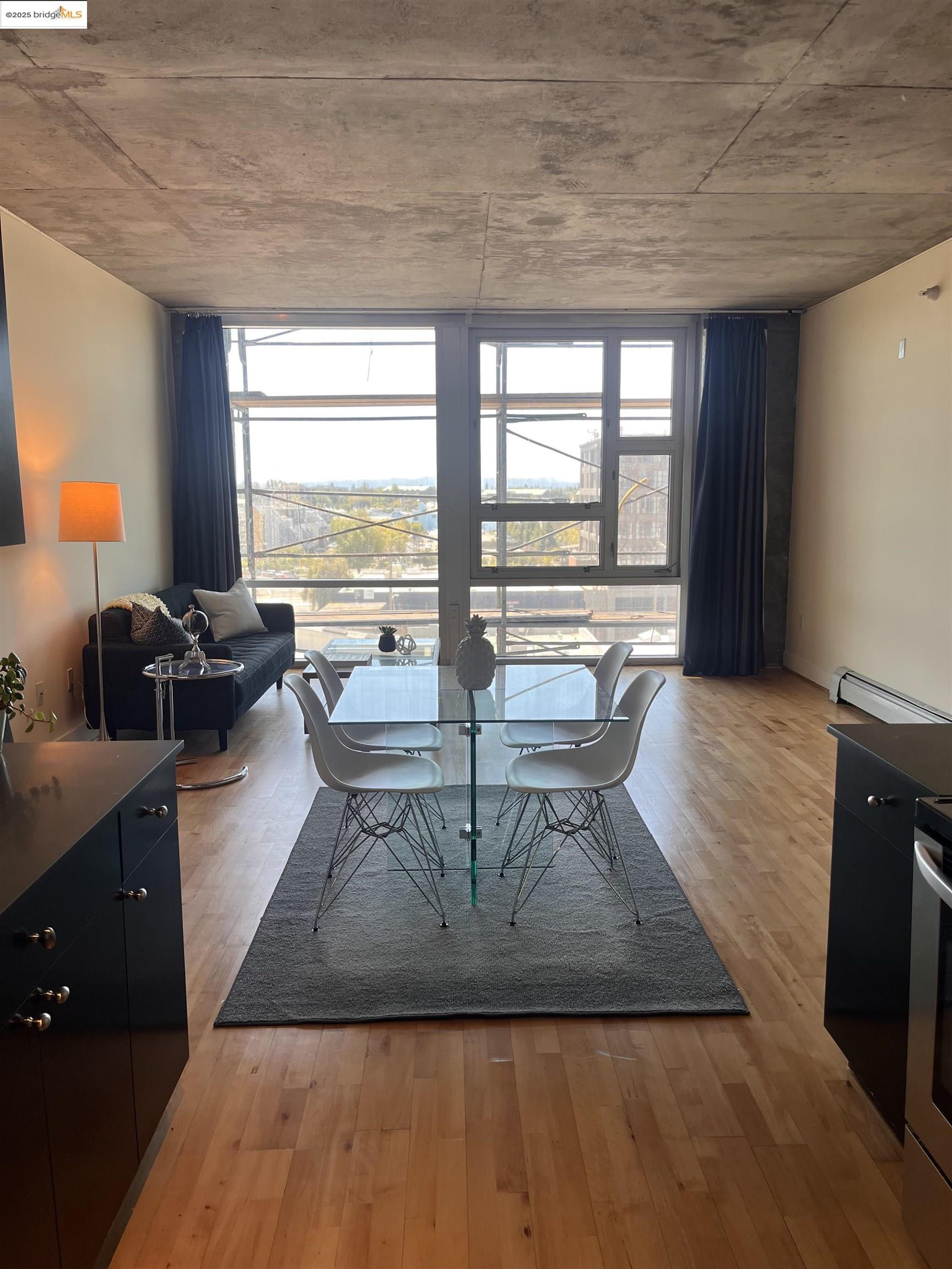 311 Oak Street, Unit 724 Oakland, CA 94607 - Photo 6 of 16 a living room with furniture a large window and wooden floor